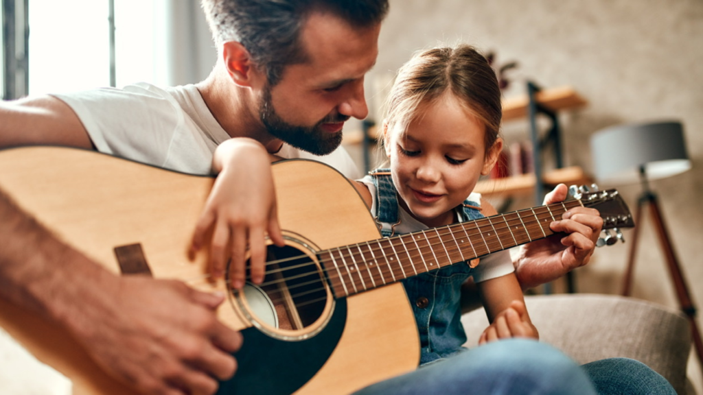 Daughter and dad playing guitar